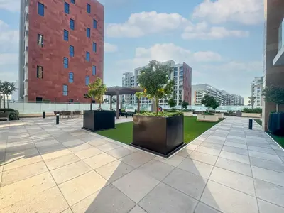 a courtyard with trees and buildings in a city at Chic Studio Azizi Riviera Retreat with City Views in Dubai