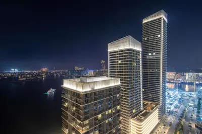 two tall skyscrapers in a city at night at Frank Porter - Marina Vista 2 in Dubai