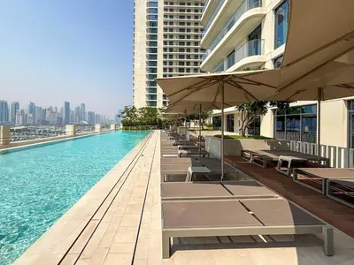 a swimming pool with tables and umbrellas on a building at Frank Porter - Marina Vista 2 in Dubai