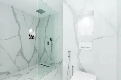 a white bathroom with a shower and a toilet at Luxury 4 Bed apartment in Murjan, JBR in Dubai