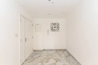 a white hallway with a clock on the wall at Luxury 4 Bed apartment in Murjan, JBR in Dubai