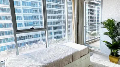 a bedroom with a bed and a large window at Elegant 1BR Apartment in Dubai LuxuryStay in Dubai