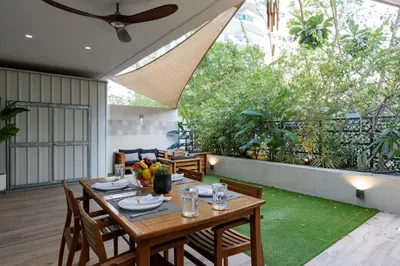 a dining room with a table and chairs on a patio at Lovey Unique Property- Garden and Barbeque Area in Dubai