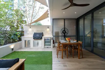 a patio with a table and chairs and a kitchen at Lovey Unique Property- Garden and Barbeque Area in Dubai