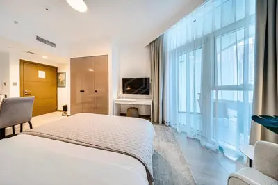 a bedroom with a white bed and a large window at Wonderful New Studio in Missoni Business Bay in Dubai