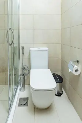 a bathroom with a toilet and a glass shower at Nasma - Modern 3BR Oasis with Balcony in Azizi Riviera in Dubai