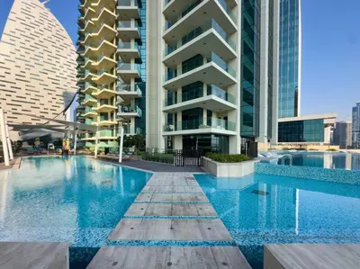 a swimming pool in front of a tall building at Luxury 1 bedroom Apartment in Urban Oasis by Missoni in Dubai