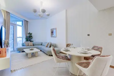 a living room with a blue couch and a table and chairs at Luxury 1 bedroom Apartment in Urban Oasis by Missoni in Dubai