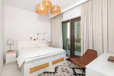 a white bedroom with a bed and a window at 3 BR Dubai Creek Harbour in Dubai