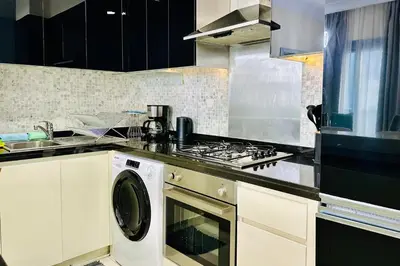 a kitchen with a stove and a washing machine at Vserve - 1 BR Iconic Burj Khalifa full view in Dubai