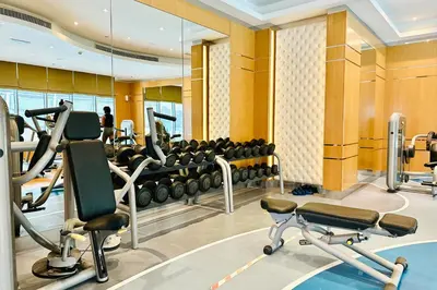 a gym with treadmills and elliptical machines at Vserve - 1 BR Iconic Burj Khalifa full view in Dubai