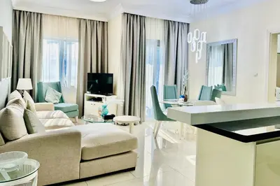 a white living room with a couch and a table at Vserve - 1 BR Iconic Burj Khalifa full view in Dubai