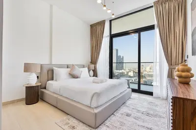 a white bedroom with a bed and a large window at Elegant - 3BR - near Palm Jumeirah - Pool and Gym in Dubai