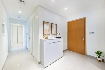 a hallway with white walls and a wooden door at Manzil - 2BR Apartment in Palm Jumeirah with Marina View in Dubai