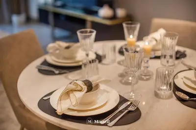 a table with plates and glasses on top of it at Manzil - 2BR Apartment in Palm Jumeirah with Marina View in Dubai
