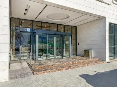 a building with glass doors on the side of it at Modern Studio with Pool, Gym and BBQ area in Dubai