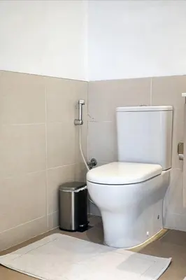a bathroom with a toilet and a trash can at First class 1BR Hall in Park Heights in Dubai