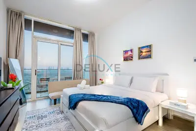 a white bedroom with a large bed and a large window at Elegant Studio in Bloom Towers B, JVC by Deluxe Holiday Homes in Dubai