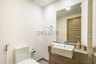 a bathroom with a sink and a toilet and a mirror at Elegant Studio in Bloom Towers B, JVC by Deluxe Holiday Homes in Dubai