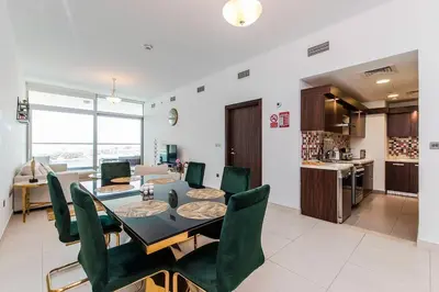 a dining room with a table and green chairs at Free Netflix, Sea View, Private Beach & Pool in Dubai