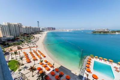 a view of a beach with umbrellas and the ocean at Free Netflix, Sea View, Private Beach & Pool in Dubai