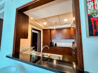 a kitchen with a sink and a mirror at Vserve - 1 BR Spacious Majestic Burj Khalifa view in Dubai