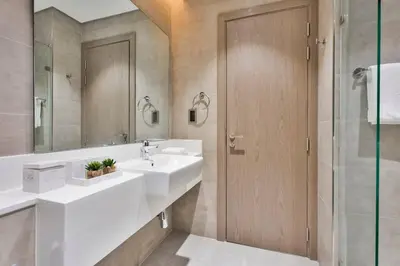 a bathroom with a white sink and a shower at Premium 1BR Haven with Burj Khalifa, City Skyline Views, Pool, Gym & Balcony in Dubai