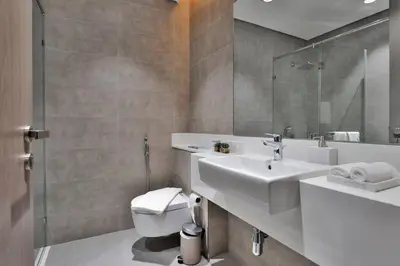 a bathroom with a sink and a toilet and a mirror at Premium 1BR Haven with Burj Khalifa, City Skyline Views, Pool, Gym & Balcony in Dubai