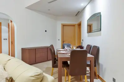 a dining room with a table and chairs and a couch at FIRST CLASS 2BR Cozy Beachfront Escape in Dubai