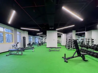 a gym with several rows of exercise equipment on a green floor at FIRST CLASS 2BR Cozy Beachfront Escape in Dubai