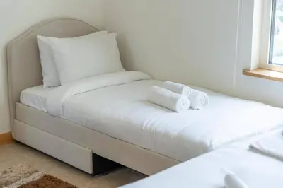 two beds in a room with two white towels at FIRST CLASS 2BR Cozy Beachfront Escape in Dubai