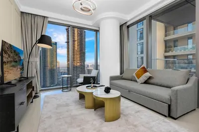 a living room with a couch and a large window at Skyline Views 2BR Near Burj Khalifa & Dubai Mall with Pool Access in Dubai