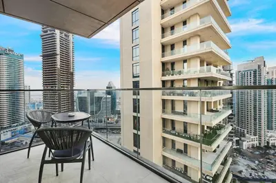 a balcony with a table and chairs and a building at Skyline Views 2BR Near Burj Khalifa & Dubai Mall with Pool Access in Dubai