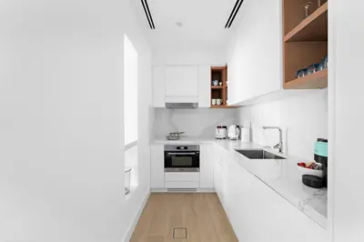 a white kitchen with white cabinets and a sink at FIRST CLASS Dubai Marina 2BR with City Views, Balcony, Pool, Gym & Parking in Dubai