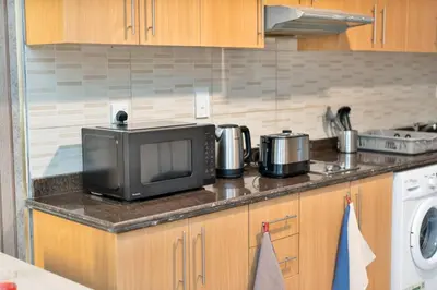 a kitchen counter with a microwave and a stove at Chic Studio Stay with Gym, Pool, and Kitchenette in Dubai