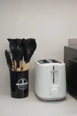 a toaster and a container of utensils next to a microwave at Burj Khalifa & Fountain Views, Pool, Free Parking in Dubai