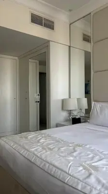 a bedroom with a large white bed and a mirror at Downtown Dubai - Damac Maison Mall Street in Dubai