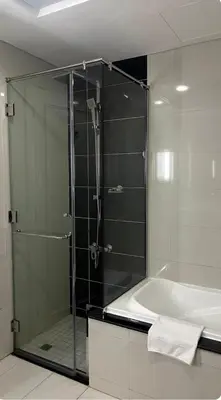 a glass shower in a bathroom with a tub at Downtown Dubai - Damac Maison Mall Street in Dubai