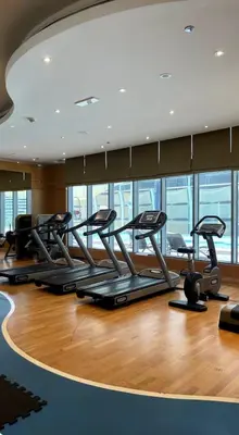 a gym with a row of treadles on a wood floor at Downtown Dubai - Damac Maison Mall Street in Dubai