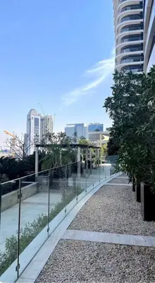 a walkway in front of a building with trees at Downtown Dubai - Damac Maison Mall Street in Dubai