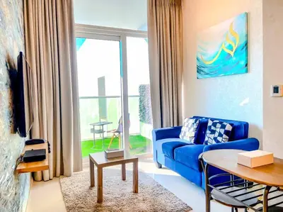 a living room with a blue couch and a table at Modern Apartment in Downtown Dubai in Dubai