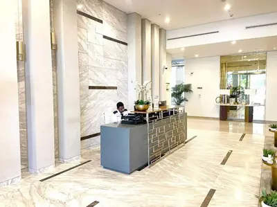 a man sitting at a counter in a lobby at Modern Apartment in Downtown Dubai in Dubai