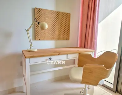 a desk with a lamp and a chair next to a window at Business bay Chic Apartment in Dubai