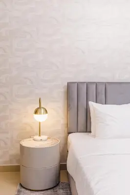 a bedroom with a bed and a table with a lamp at Burj Khalifa View Apartment 10 min Walking to Dubai Mall in Dubai