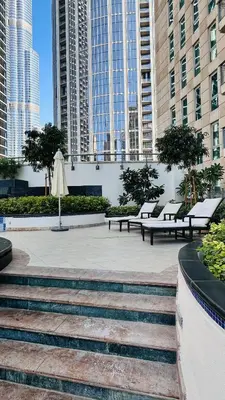 a park with benches and an umbrella in a city at Burj Khalifa View Apartment 10 min Walking to Dubai Mall in Dubai