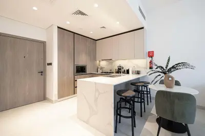 a kitchen with a island with bar stools in it at Legacy by Sunrise - Top Amenities and Paddle Court in Dubai