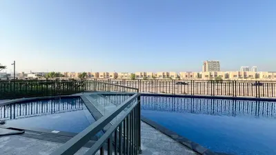a pool of water with a fence and a city at Legacy by Sunrise - Top Amenities and Paddle Court in Dubai