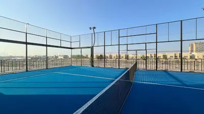 a tennis court with a net on top of it at Legacy by Sunrise - Top Amenities and Paddle Court in Dubai