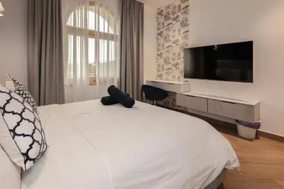 a bedroom with a white bed with a tv on the wall at Luxurious Villa 5BHK with Pool BBQ and Full Time Housemaid Assistance - live in in Dubai
