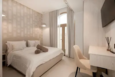 a white bedroom with a bed and a chair at Luxurious Villa 5BHK with Pool BBQ and Full Time Housemaid Assistance - live in in Dubai